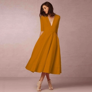 Detail of elegant mustard yellow midi dress with deep V-neck and stylish flare skirt