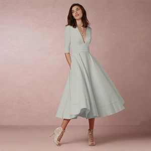 Detail of the deep V-neckline and silver-grey flared dress with waist-slimming cut
