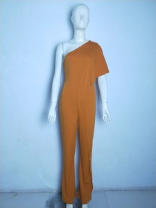Detailed view of single shoulder jumpsuit with asymmetrical layered ruffles in mustard yellow