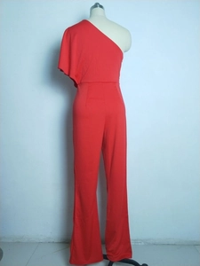 Detail of red one-shoulder jumpsuit featuring ruffle sleeve and wide leg design