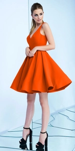 Détail d'une robe orange sans manches avec col en V profond et jupe évasée structurée