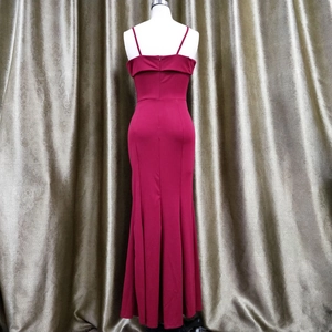 Detail of burgundy off-shoulder evening dress featuring a fishtail hem and slim straps