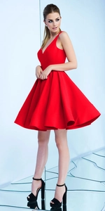 Détail d'une robe de cocktail rouge élégante avec décolleté en V et jupe plissée en A