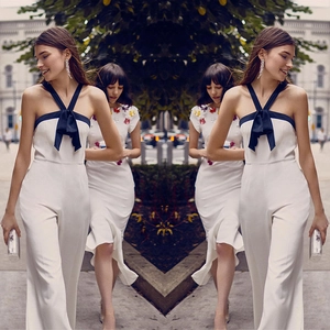 Elegant white wide-leg jumpsuit with black bow and halter neck in mirror effect