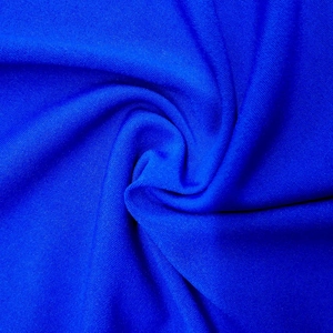 Texture macro détaillée du tissu en maille piquée bleu roi montrant un drapé souple