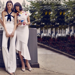 Detail of white halter jumpsuit with black bow and dress with 3D floral appliqués