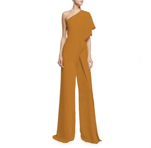 Detail of elegant one-shoulder mustard yellow jumpsuit with draped cape sleeve and wide legs