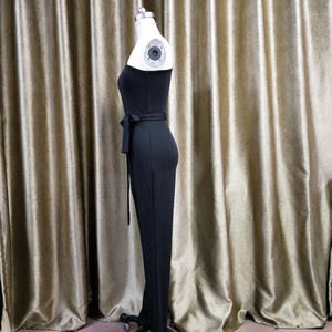Detail of slim fit black strapless jumpsuit with matching bow tie waist belt detail