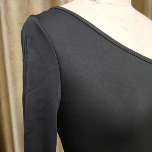 Detail view of black asymmetric shoulder design with high-density knit fabric