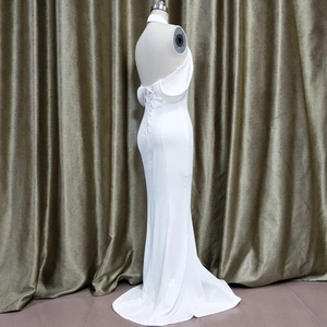 Detailed back view of white evening dress featuring corset lacing and open back design