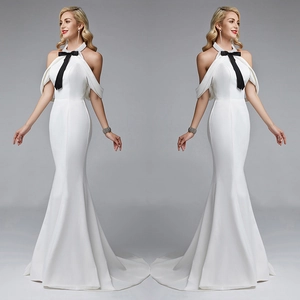 Elegant white fishtail evening dress with halter neck and black bow decorative ribbons