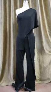 Detail of black one-shoulder jumpsuit featuring asymmetric draped layers and wide-leg cut