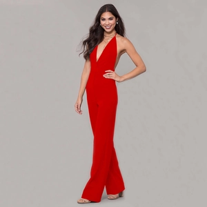 Detail of red halter neck jumpsuit featuring a deep V-neck and wide leg design