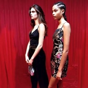 Detail shot of a black silk camisole and a floral jacquard mini dress on models