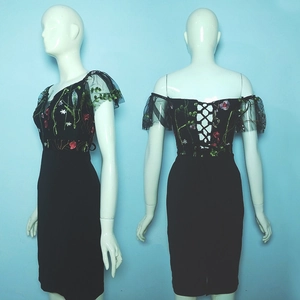 Detail of floral embroidery on black mesh dress with adjustable lace-up back design