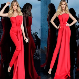 Detailed view of red strapless jumpsuit featuring a long draped skirt and waist pleats