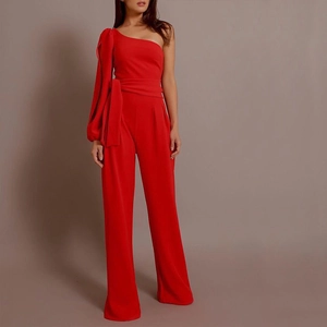 Detail of red one-shoulder jumpsuit with wide belt and elegant wide-leg trousers