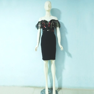 Detail of floral embroidery on off-shoulder mesh sleeves of a black bodycon dress