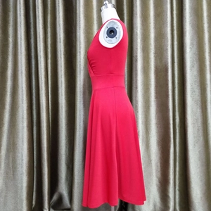 Detail of red sleeveless A-line cocktail dress showing side pleats and waistline on mannequin