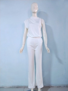 Detail of elegant white one-shoulder jumpsuit with draped neck and wide-leg trousers