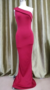 Détail d'une robe de soirée rouge à une épaule avec décolleté replié et coupe sirène élégante