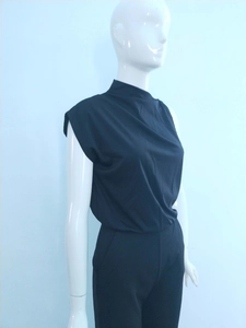 Detailed view of black mock neck sleeveless jumpsuit fabric and waist tailoring