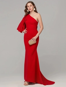 Detail of red one-shoulder evening gown with ruffled sleeve and mermaid tail design