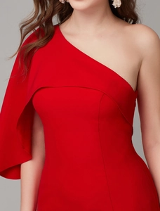 Detail of the elegant asymmetric ruffled shoulder design on a vibrant red evening gown