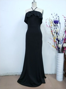 Detail of black evening gown with spaghetti straps and ruffled sleeves on mannequin