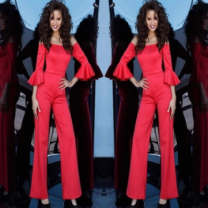 Detail of red off-shoulder jumpsuit featuring dramatic tiered bell sleeves and wide legs