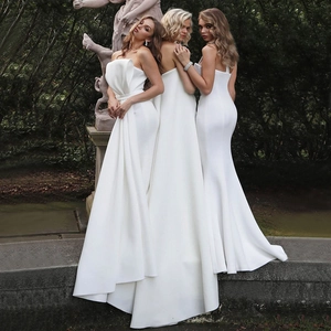 Elegant white strapless jumpsuit with trailing cape and bow detail for formal evening events
