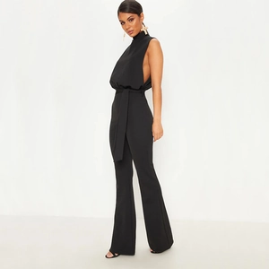 Detail view of black sleeveless high-neck jumpsuit with waist tie and flared leg silhouette
