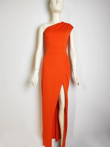 Detail of orange one-shoulder maxi dress with side slit and waist pleats for formal events