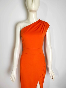 Detail view of orange one-shoulder dress showing front slit and ruffled fabric texture