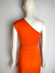 Detail of orange one-shoulder maxi dress with high waist seam and fitted matte fabric