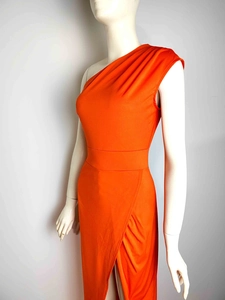 Detail of orange one-shoulder evening dress featuring side slit and ruched waist