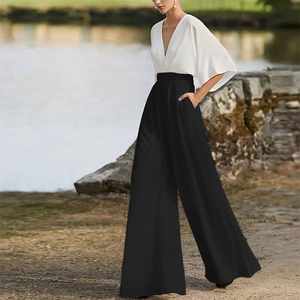 Detail of white deep V-neck top with flare sleeves and black high-waist wide-leg pants
