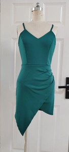 Detail of dark green V-neck evening dress featuring pleated wrap skirt and side slit