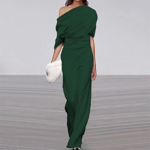 Detail of forest green off-shoulder jumpsuit featuring draped pleated top and wide-leg trousers