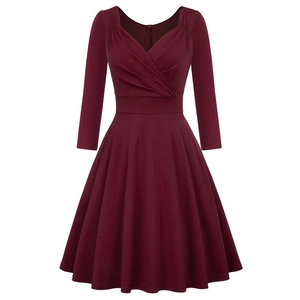 Detail view of burgundy cocktail dress featuring a deep V-neck and pleated A-line skirt
