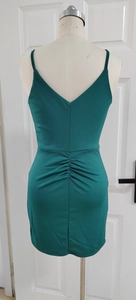 Detail of deep green bodycon dress featuring delicate straps and elegant back ruching