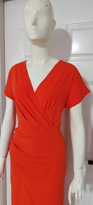 Detailed view of the red V-neck wrap dress featuring elegant waist pleats and slim fit design