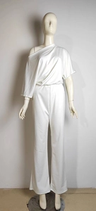 Detailed view of the white one-shoulder pleated top and high waist wide leg pants set