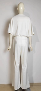 Rear view of woman in white two-piece set featuring short sleeve top and straight-leg pants