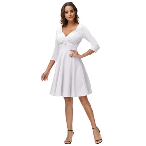 Detailed view of white dress with cross V-neckline and elegant three-quarter sleeves