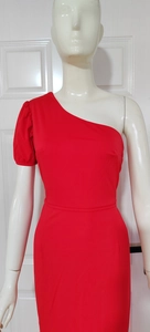Detail of red one-shoulder dress with puff sleeve and slim waist on mannequin