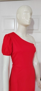 Detail of red one-shoulder dress showing the puff sleeve and asymmetrical neckline