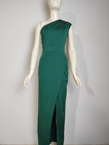 Detail view of the one-shoulder neckline and high waist slit on the dark green dress
