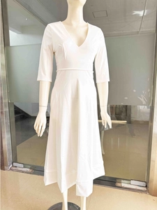 Détail d'une robe de soirée blanche élégante à col en V, manches mi-longues et taille ajustée