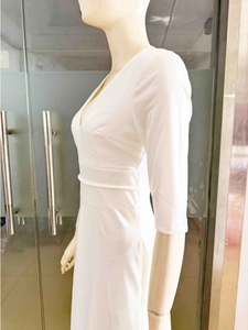 Détail de la robe blanche à col en V avec manches mi-longues et taille cintrée large